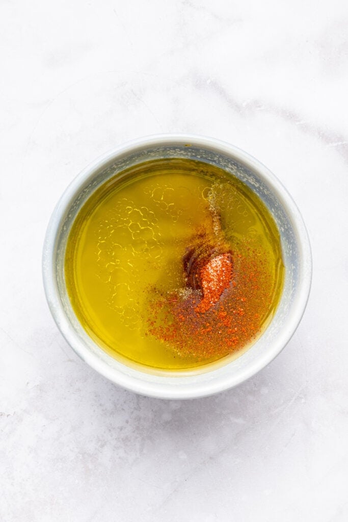 Overhead view of ingredients for vinaigrette in small bowl