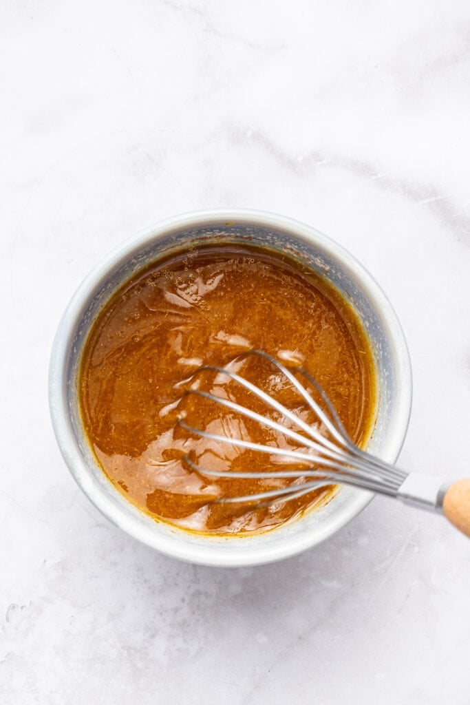 Overhead view of whisking vinaigrette in small bowl