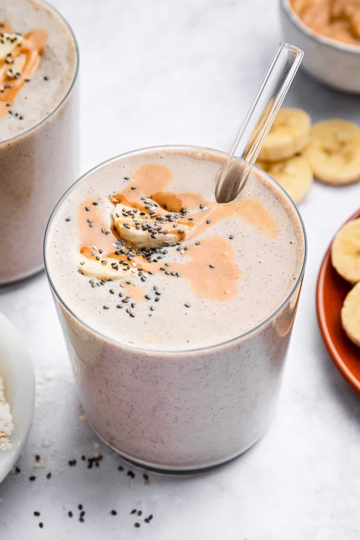 Peanut butter banana smoothie topped with bananas, chia seeds, and peanut butter