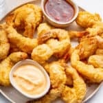Plate of shrimp tempura with two small bowls of sauce