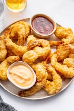 Plate of shrimp tempura with two small bowls of sauce