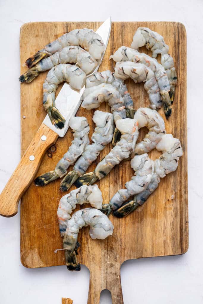 Shrimp on cutting board with knife