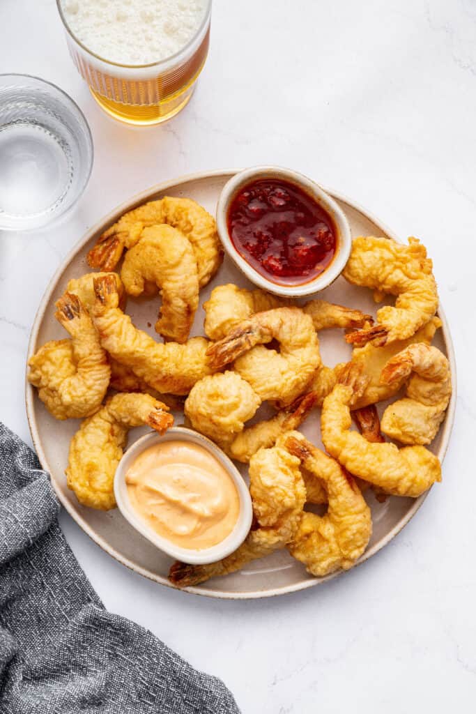 Plate of shrimp tempura with two small bowls of sauce