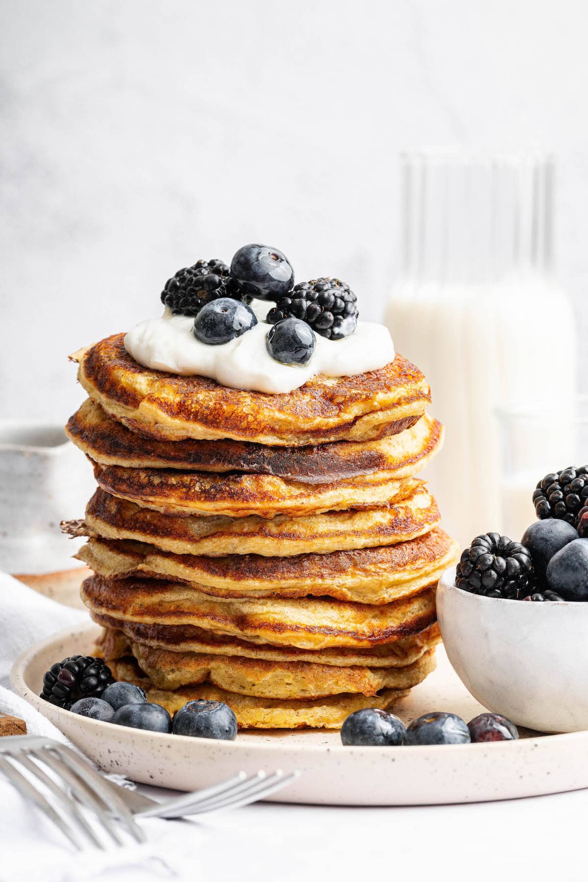Cottage cheese pancakes are tender and fluffy, with more protein than a traditional pancake. Stash some in the freezer for easy breakfasts! Stack of cottage cheese pancakes topped with berries and yogurt