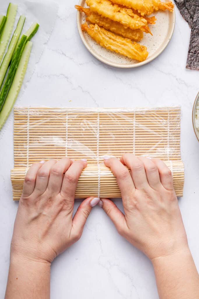 Rolling dragon roll in sushi mat