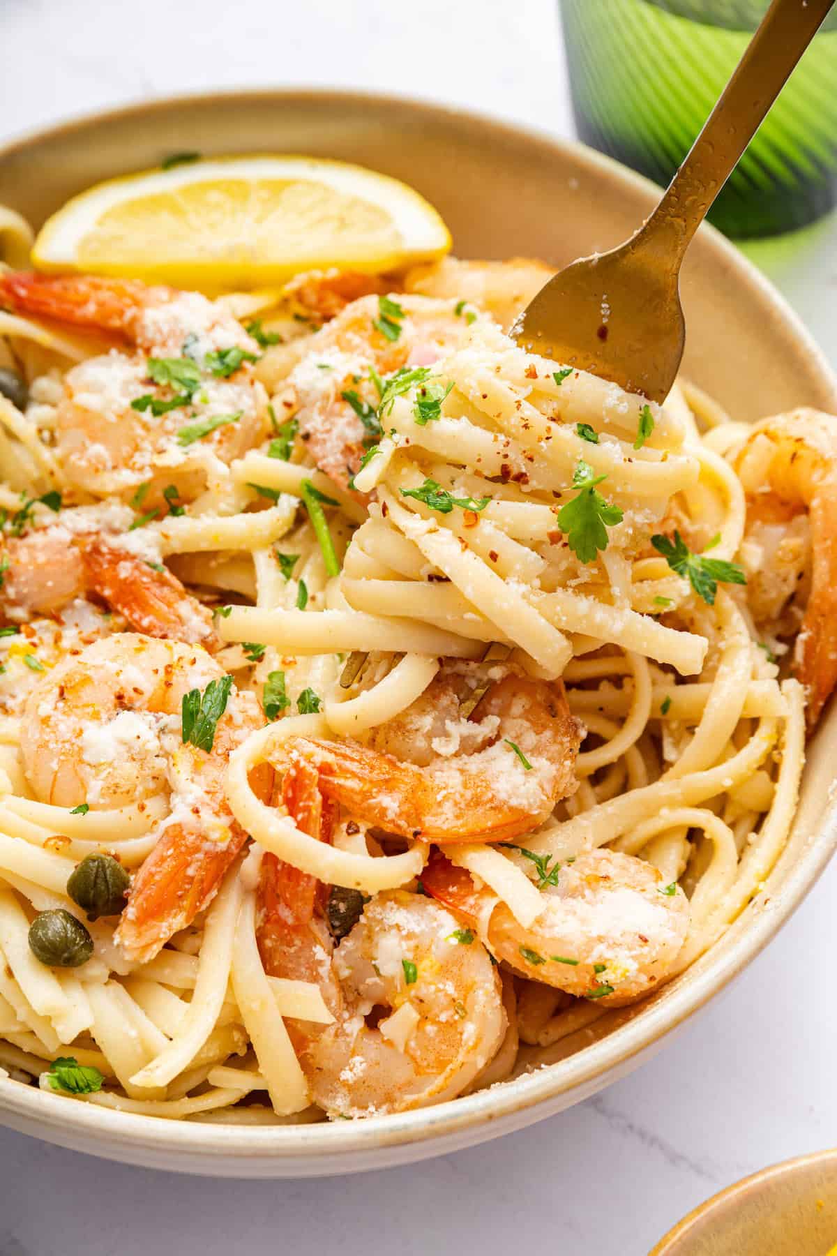 Fork digging into bowl of shrimp scampi