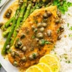 Lemon caper chicken on plate with rice and asparagus