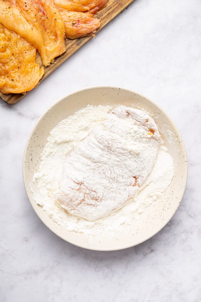 Dredging chicken cutlet in flour