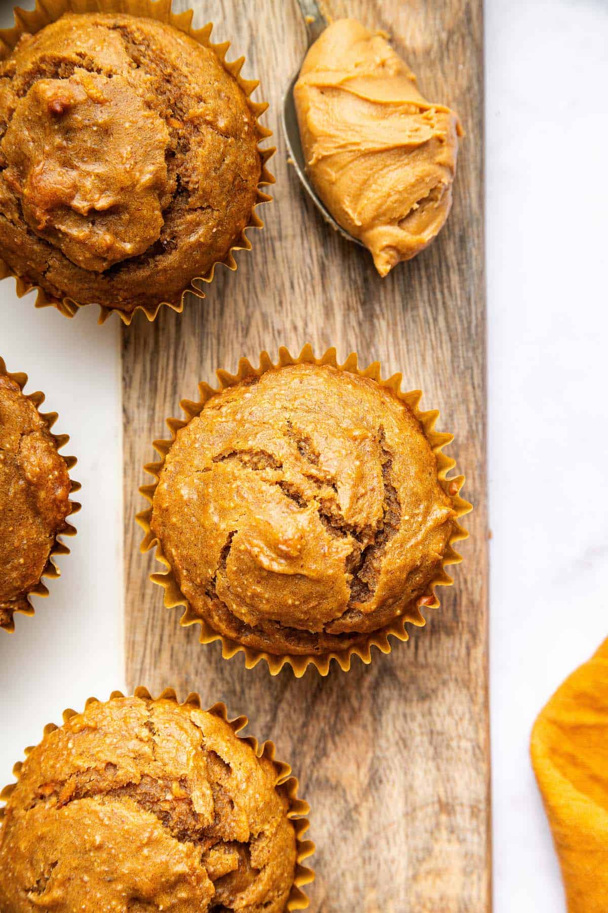 These peanut butter banana muffins are a wholesome way to start your day and I add an unexpected ingredient to make them tender and moist! Overhead view of peanut butter banana muffins on board