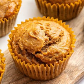 Closeup of peanut butter banana muffin on wooden board