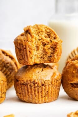 Stack of 2 peanut butter banana muffins with top one bitten to show light texture