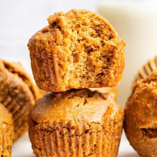 Stack of 2 peanut butter banana muffins with top one bitten to show light texture