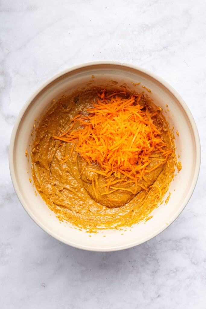 These peanut butter banana muffins are a wholesome way to start your day and I add an unexpected ingredient to make them tender and moist! Carrots added to bowl of batter