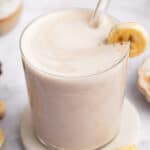 Glass of creamy banana milk with straw