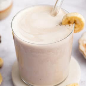 Glass of creamy banana milk with straw