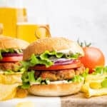 Two chicken burgers on wood and marble board