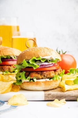 Two chicken burgers on wood and marble board