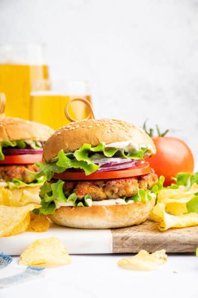 Two chicken burgers on wood and marble board