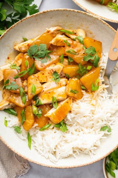 Overhead view of pineapple chicken in bowl with white rice