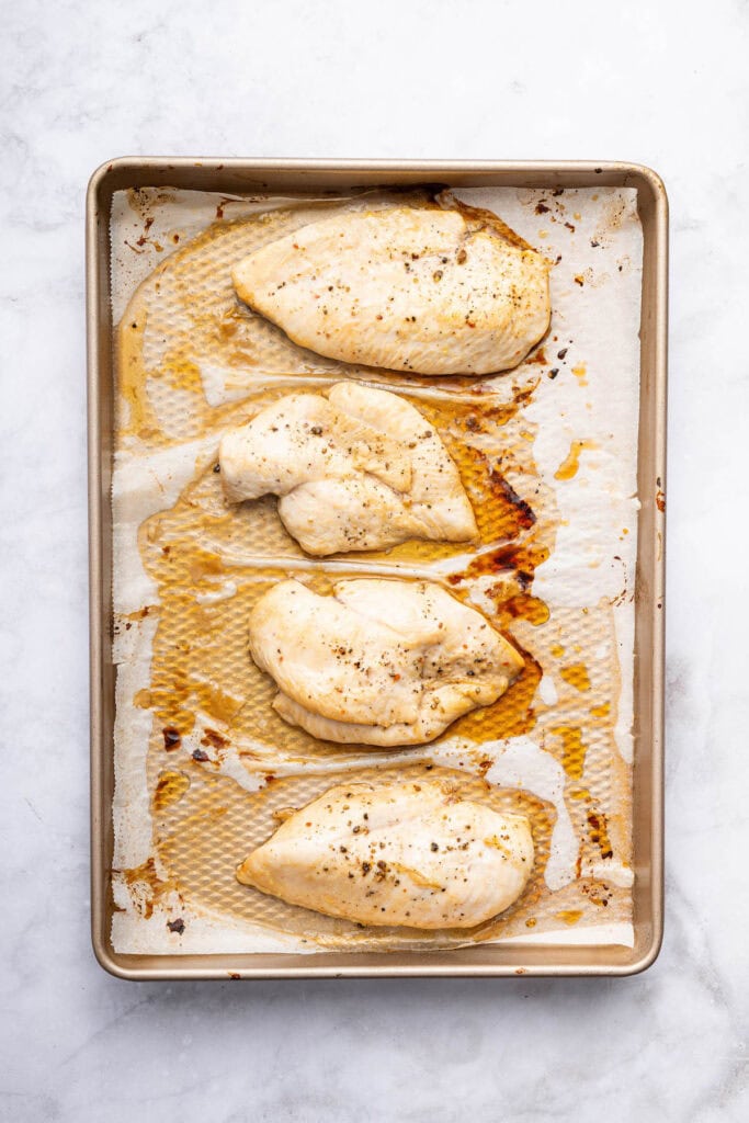 Overhead view of chicken breasts cooked on sheet pan