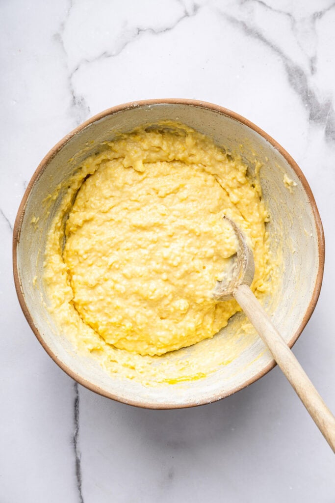 This blueberry peach cobbler recipe pairs two summer favorites in a jammy filling that’s baked with a buttery, flaky topping. So easy! Overhead view of cobbler topping in bowl with spoon