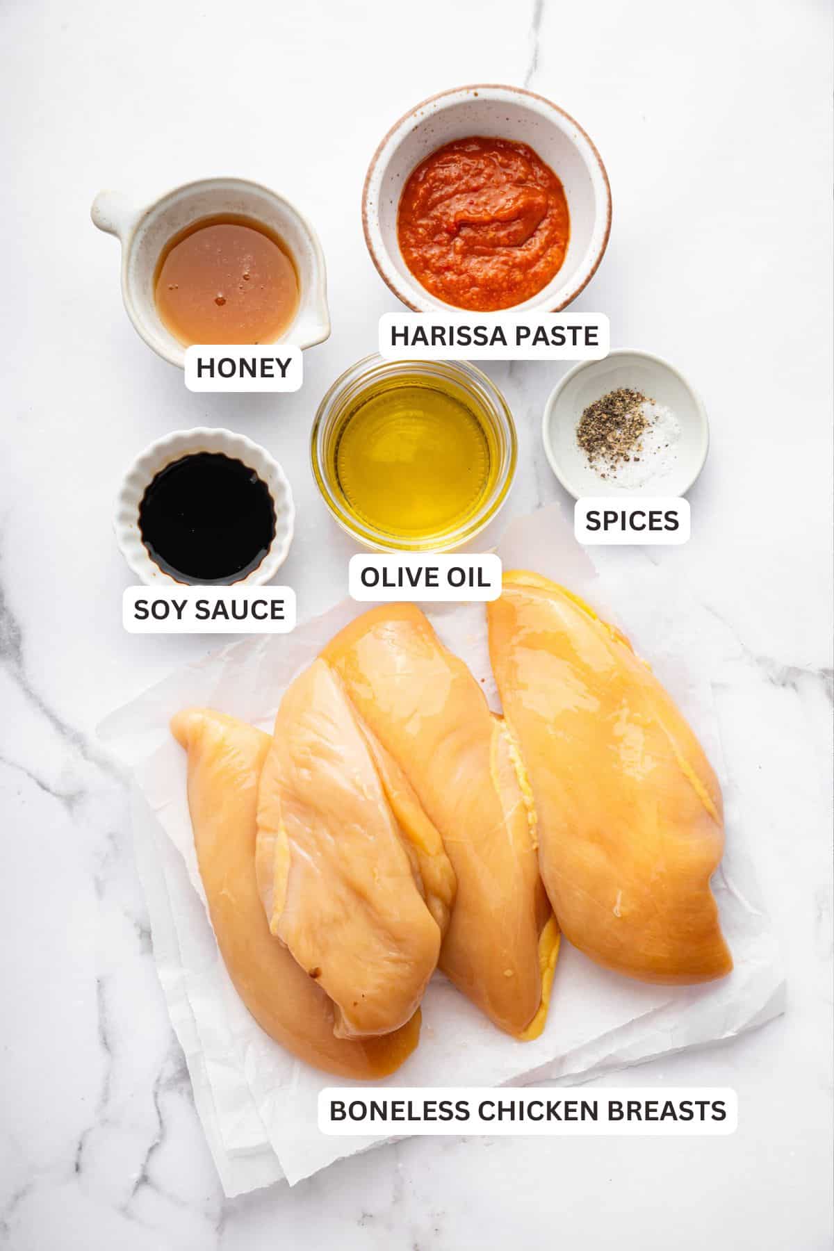 Overhead view of ingredients for harissa honey chicken with labels.