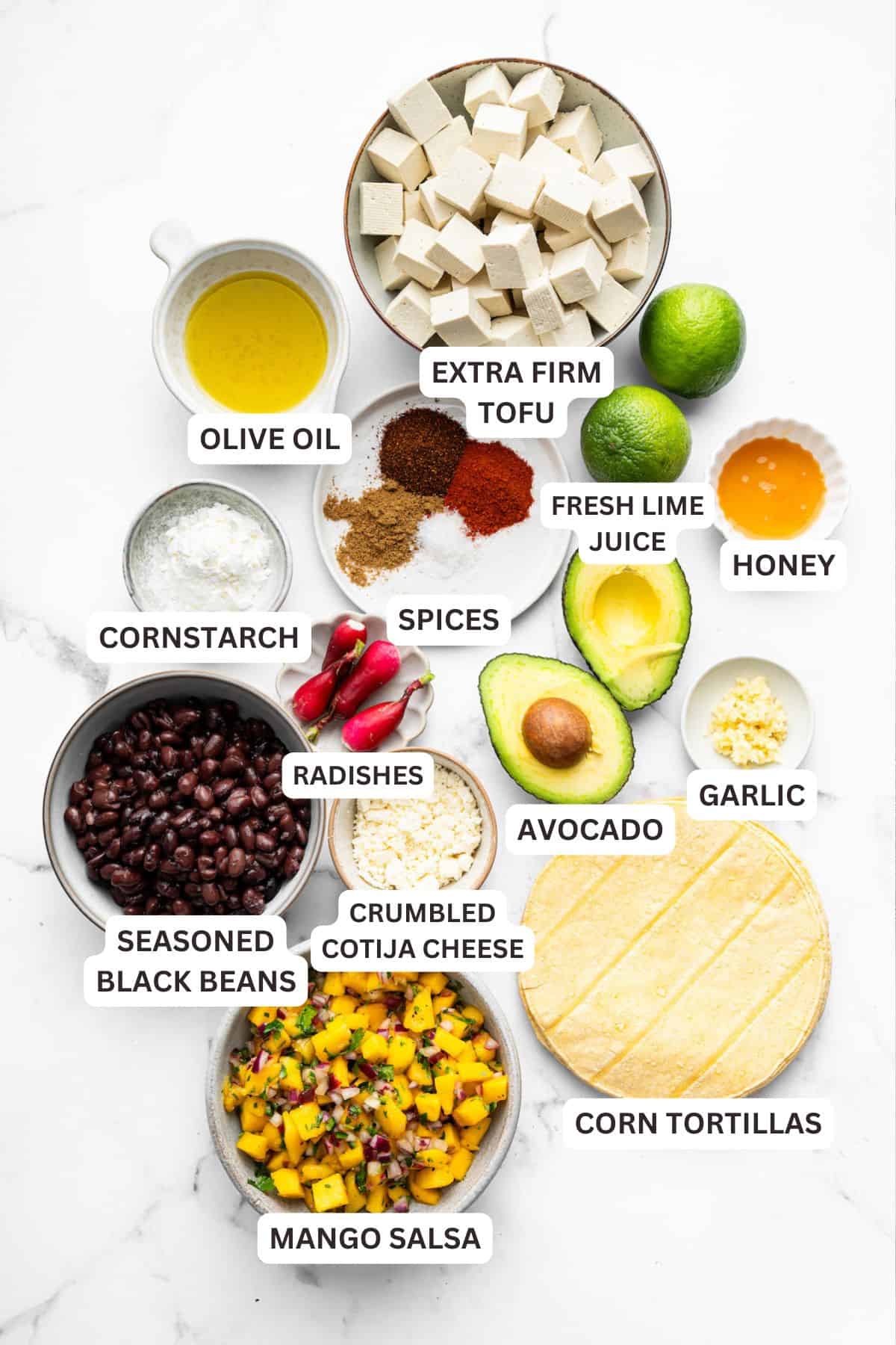 With black beans, crispy tofu and a sweet, tangy mango-peach salsa, these Air Fryer Tofu Tacos are the tastiest meatless dinner ever! Overhead view of air fryer tofu taco ingredients with labels