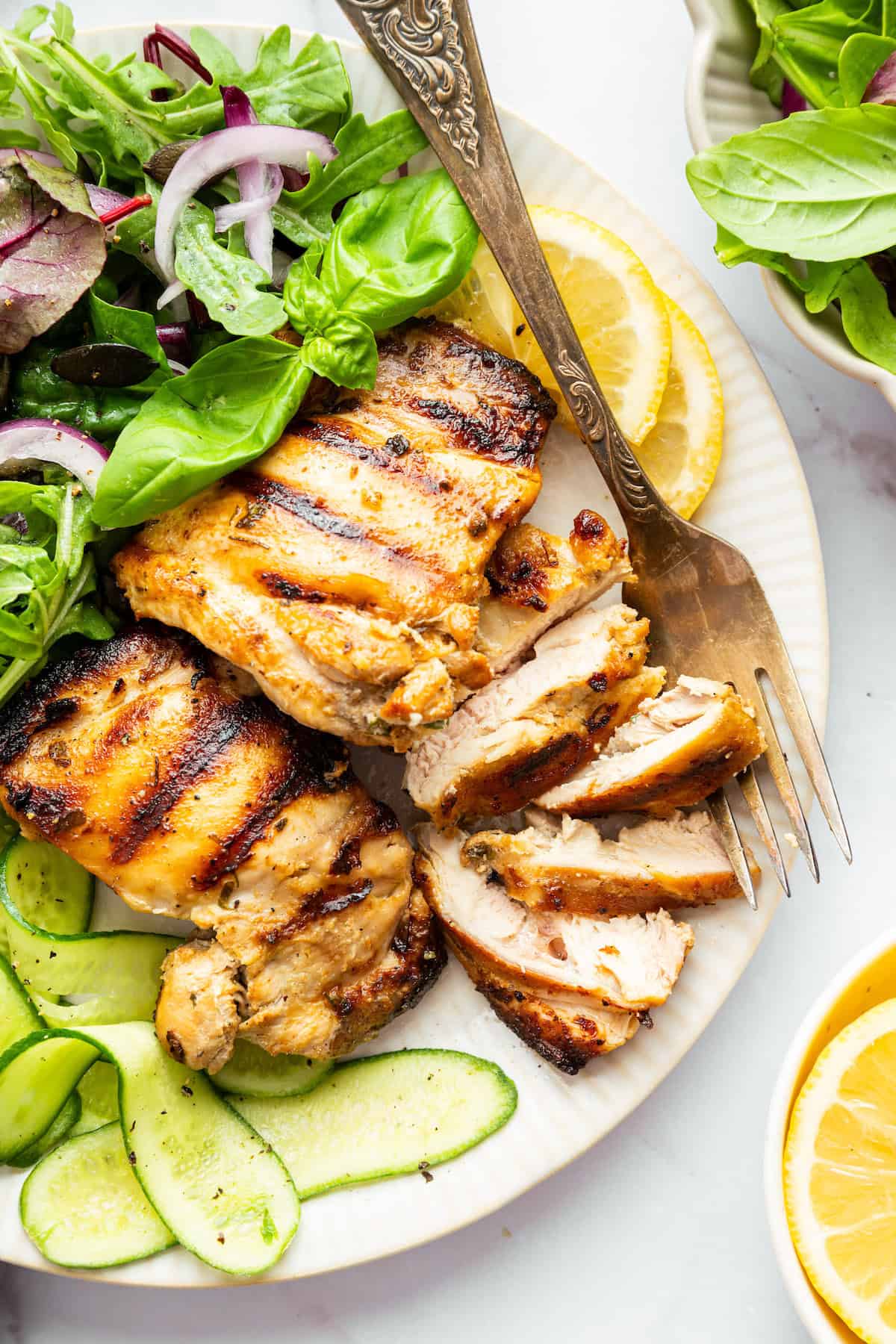 Closeup of Greek yogurt chicken on plate with fork and salad