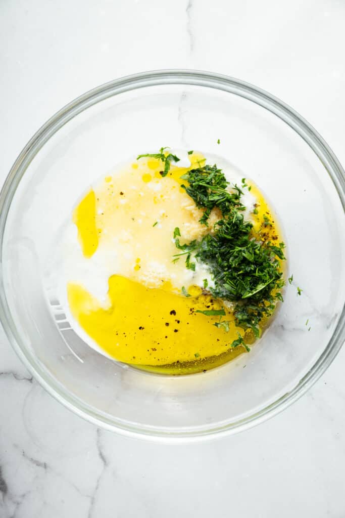 Overhead view of ingredients for Greek yogurt marinade in bowl before stirring