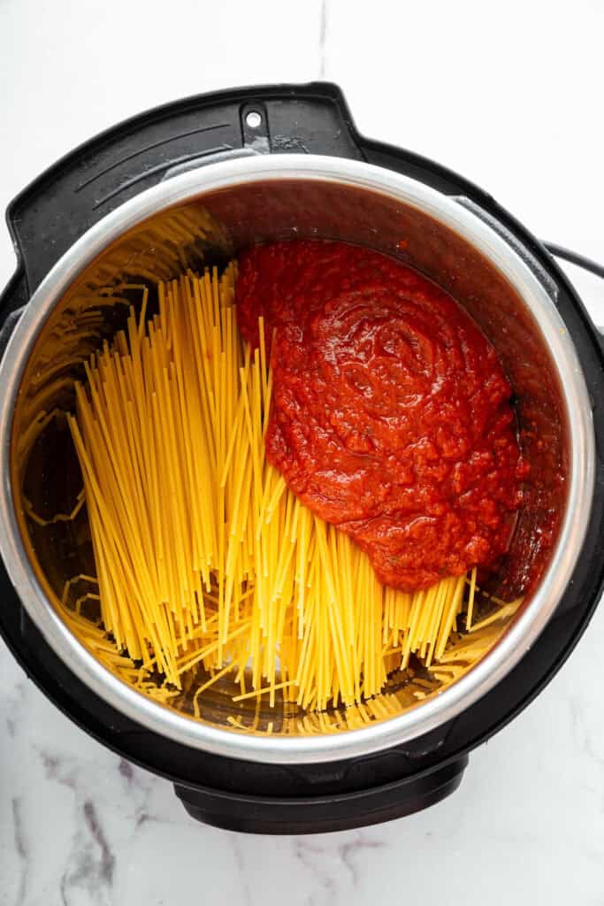 This two-ingredient Instant Pot Spaghetti cooks the pasta in the sauce, and it does it in a pressure cooker so it takes just 20 minutes! Dry spaghetti in Instant Pot with sauce
