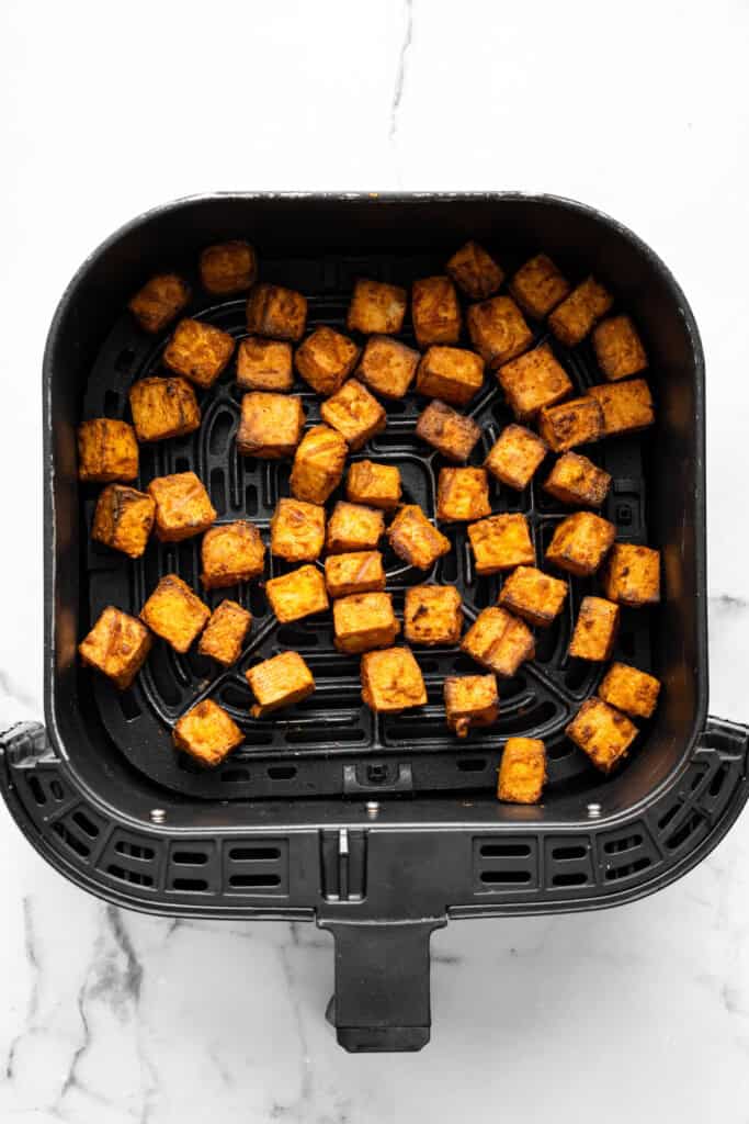 With black beans, crispy tofu and a sweet, tangy mango-peach salsa, these Air Fryer Tofu Tacos are the tastiest meatless dinner ever! Overhead view of tofu in air fryer basket