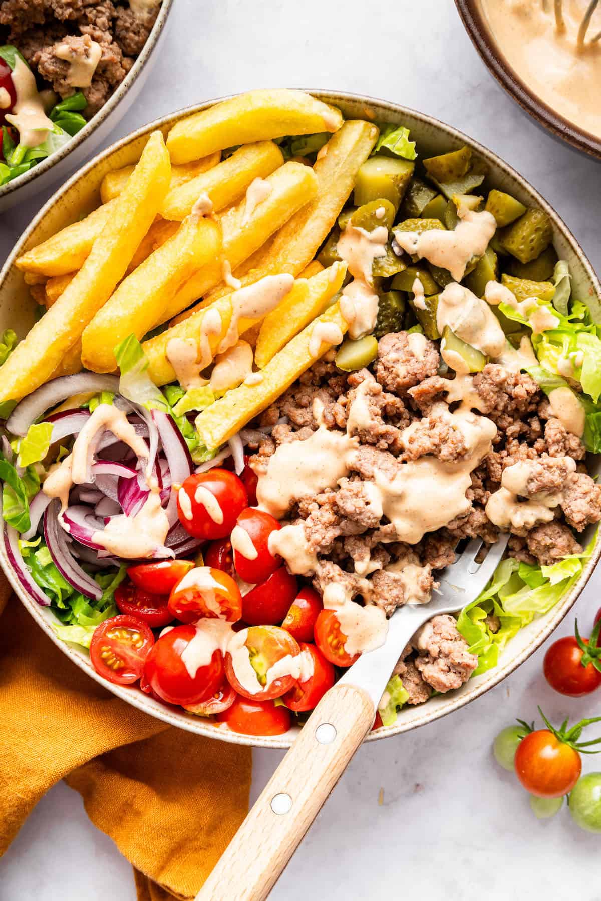 This Burger Bowl recipe gives you your burger fix, without the bun! It’s a fun protein-packed meal with crispy fries and your fave toppings. Burger bowl with fries and special sauce.