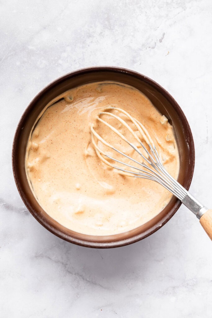 This Burger Bowl recipe gives you your burger fix, without the bun! It’s a fun protein-packed meal with crispy fries and your fave toppings. Whisking special sauce in bowl.