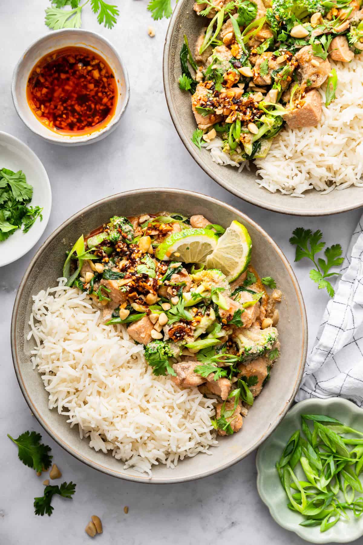 This flavorful Salmon Curry is a 30-minute dinner with creamy coconut sauce, broccoli and spinach. Serve over rice for a filling meal! Two bowls of salmon curry with jasmine rice.