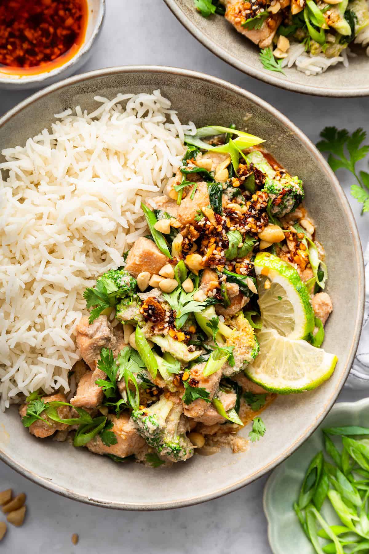 This flavorful Salmon Curry is a 30-minute dinner with creamy coconut sauce, broccoli and spinach. Serve over rice for a filling meal! Salmon curry in bowl with white rice.