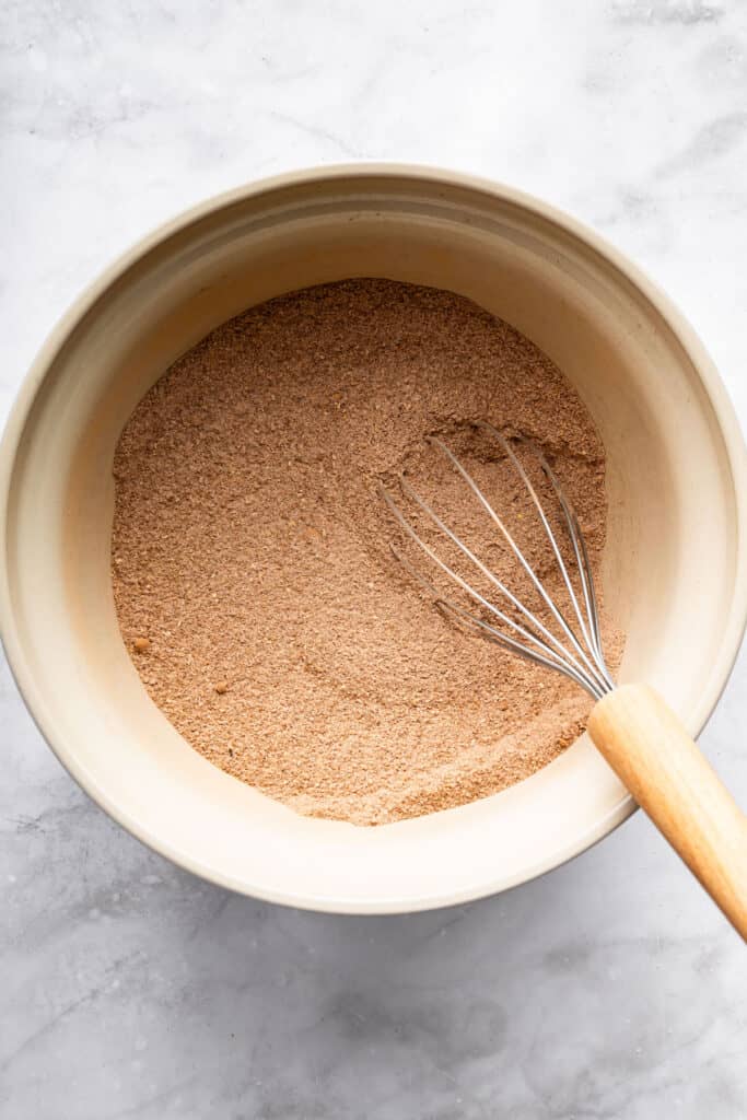 These easy Cottage Cheese Brownies are the perfect wholesome indulgence, with extra protein and whole grains in a rich, fudgy brownie! Dry ingredients for brownies in bowl with whisk.