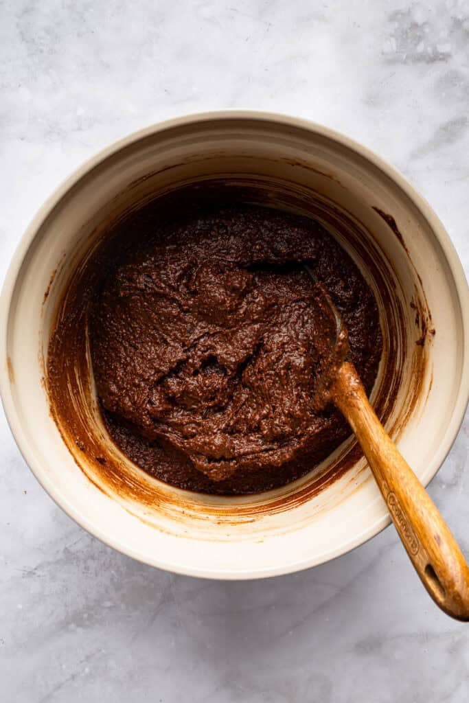 These easy Cottage Cheese Brownies are the perfect wholesome indulgence, with extra protein and whole grains in a rich, fudgy brownie! Batter for cottage cheese brownies in bowl with wooden spoon.