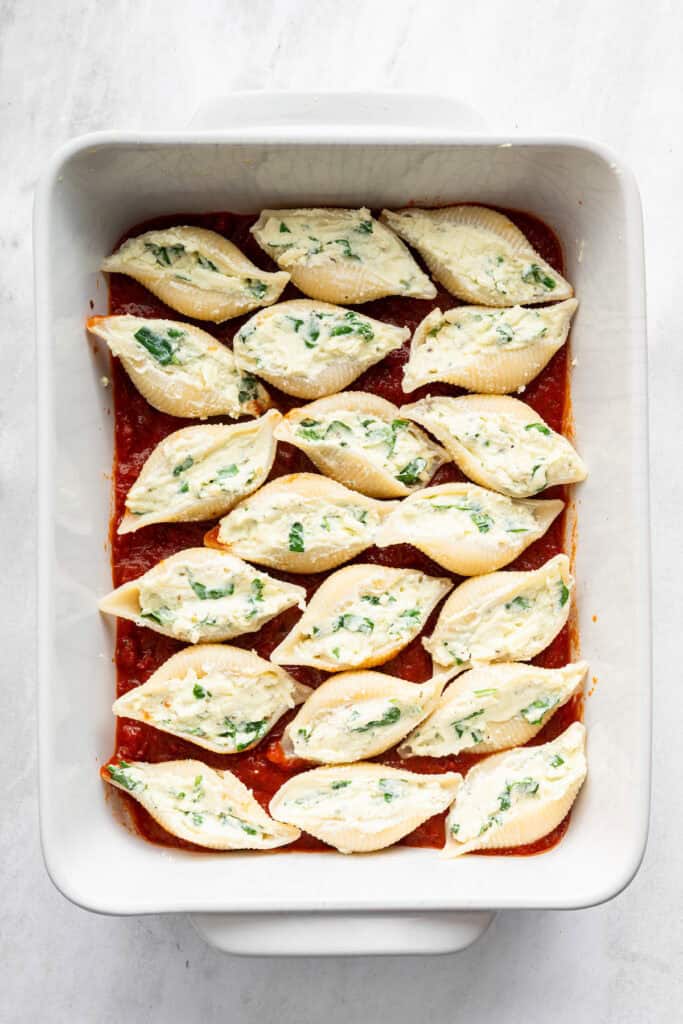 Stuffed shells in baking dish before adding marinara and cheese on top.