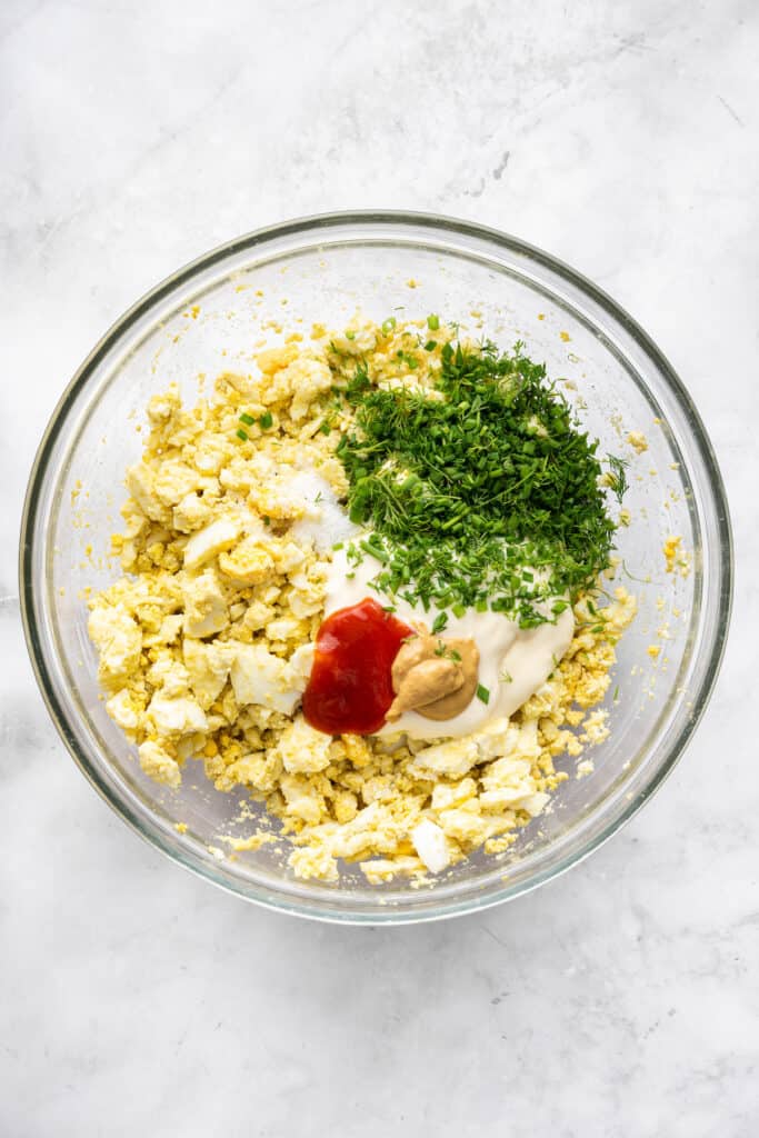 Ingredients for egg salad in bowl before mixing.