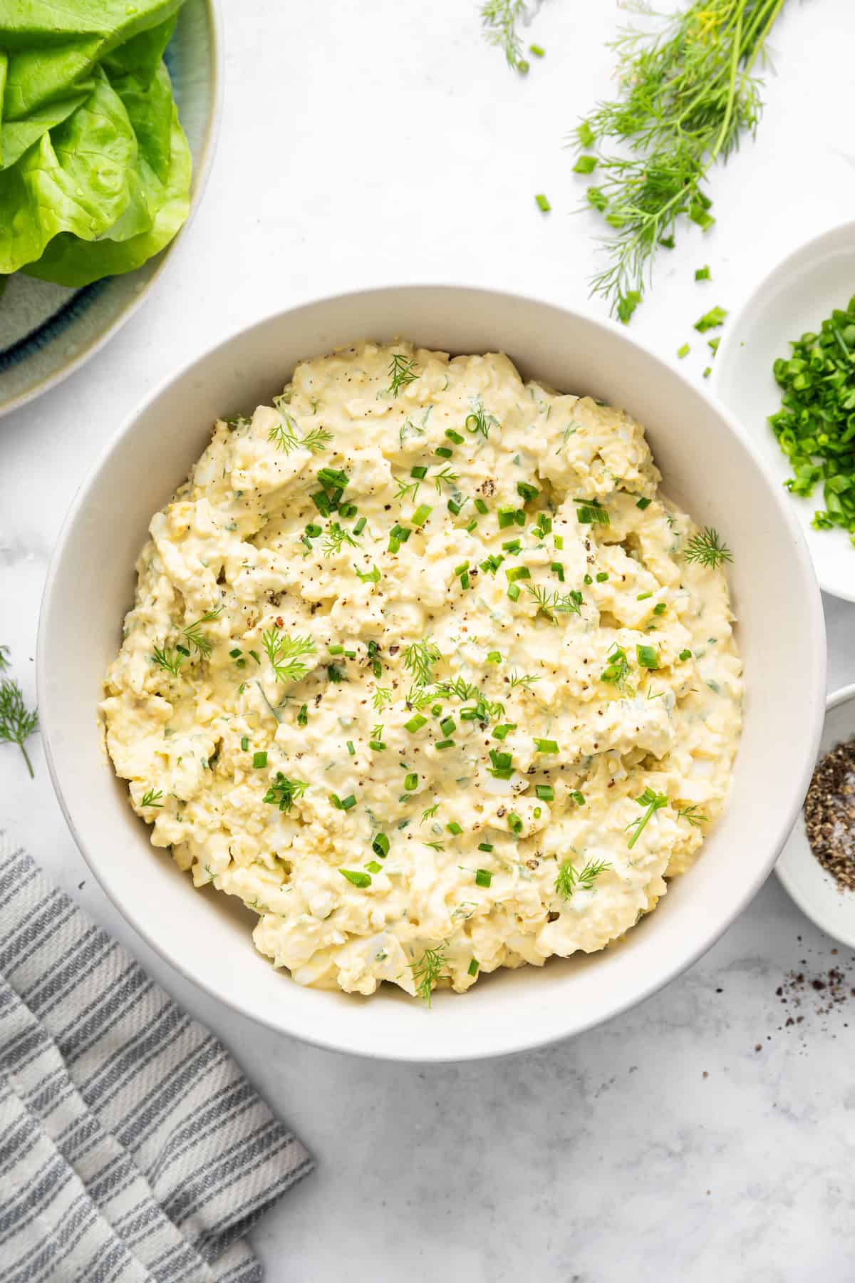 Bowl of egg salad with fresh herbs.