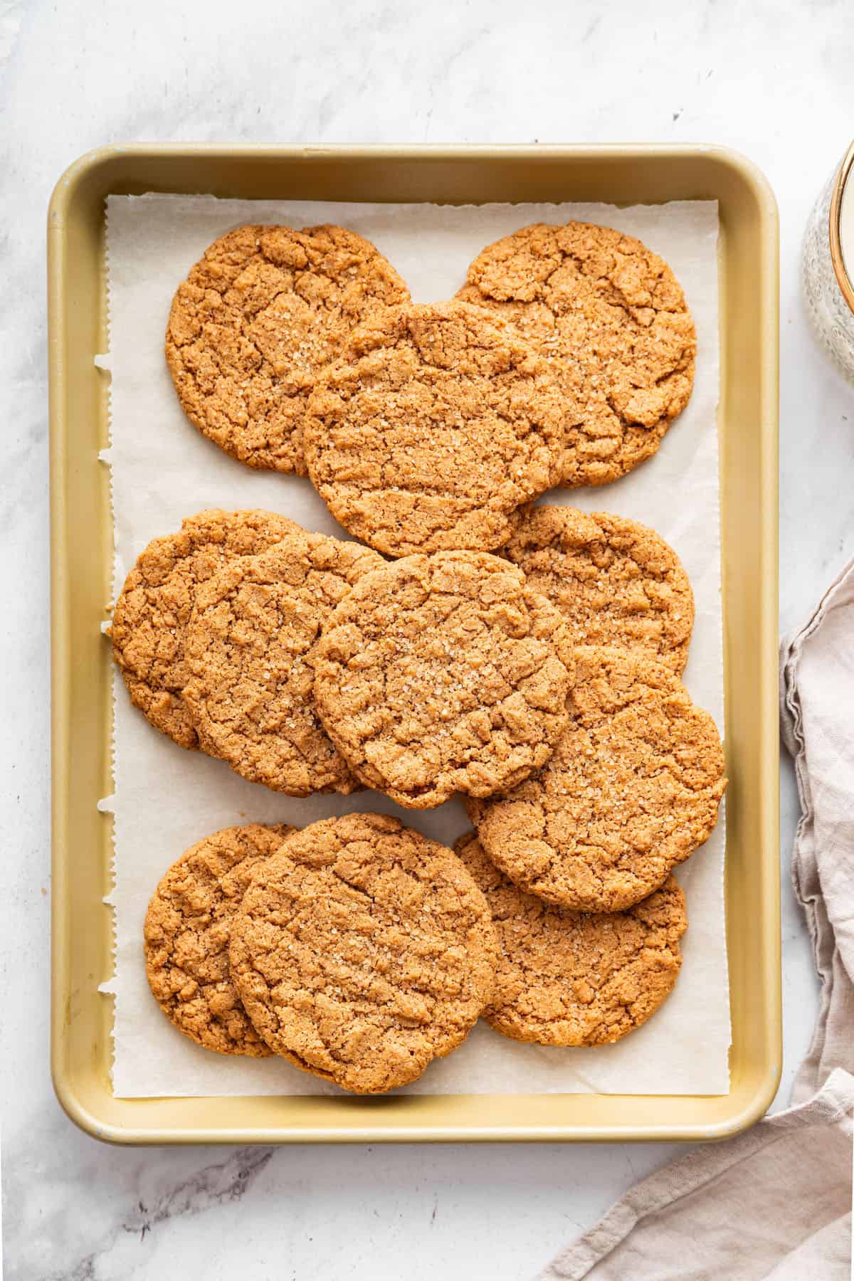 These easy almond butter cookies are made with just 5 ingredients! Naturally gluten-free, chewy with crisp edges, and full of nutty flavor. Almond butter cookies piled onto parchment-lined baking sheet.