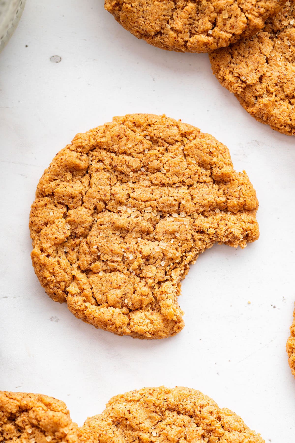 These easy almond butter cookies are made with just 5 ingredients! Naturally gluten-free, chewy with crisp edges, and full of nutty flavor. Almond butter cookie on counter with bite taken out.