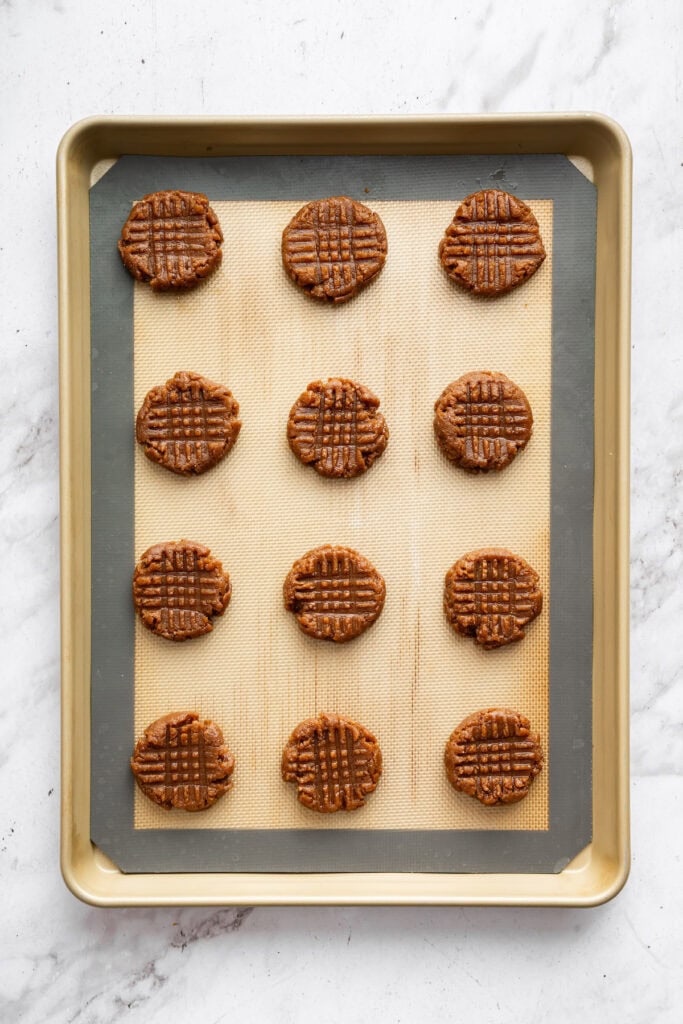 These easy almond butter cookies are made with just 5 ingredients! Naturally gluten-free, chewy with crisp edges, and full of nutty flavor. Unbaked almond butter cookies on silpat lined pan.