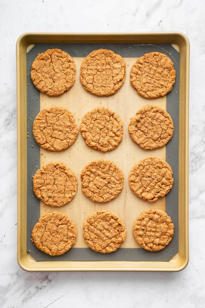 These easy almond butter cookies are made with just 5 ingredients! Naturally gluten-free, chewy with crisp edges, and full of nutty flavor. Baked almond butter cookies on pan with silpat.