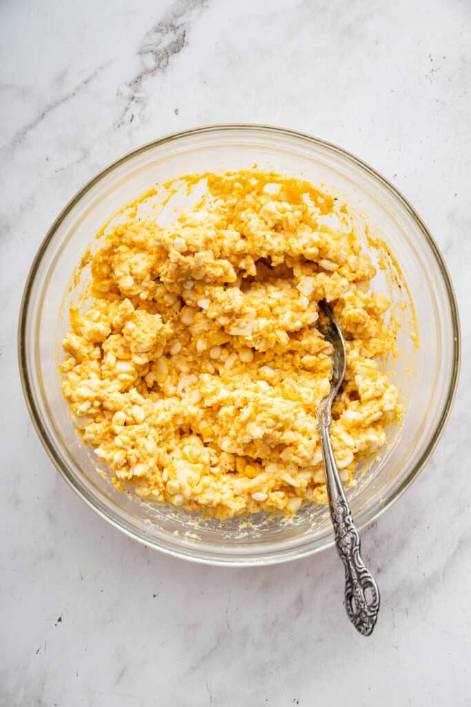 This creamy cottage cheese egg salad is a lighter version of the classic made without mayo. Higher in protein and perfect for meal prep! Spoon in bowl of cottage cheese egg salad.