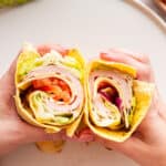 Hands holding two halves of cottage cheese wrap.