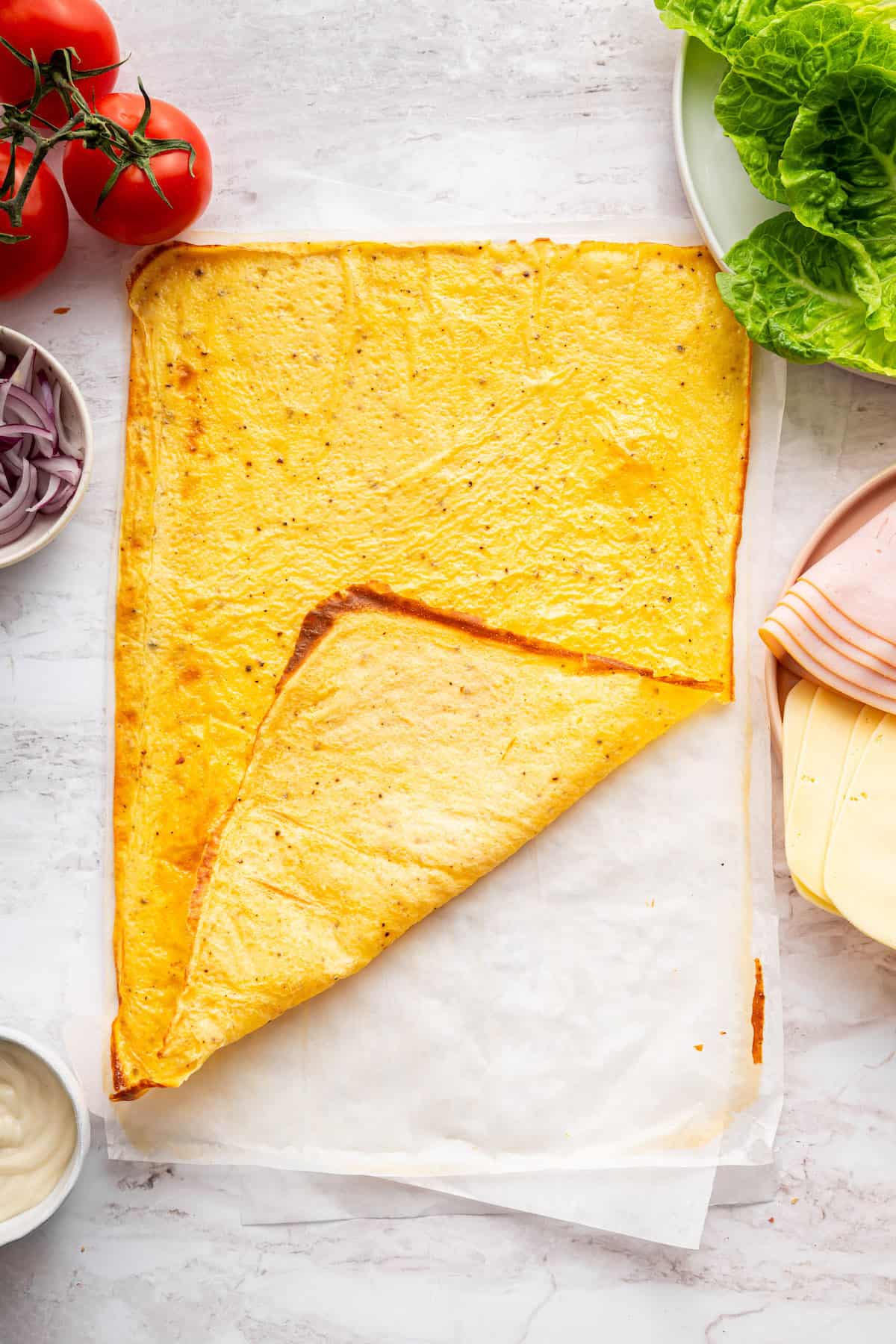 These high protein cottage cheese wraps are made with eggs and pantry seasonings—that’s it. An easy low carb alternative that tastes delish! Cottage cheese wrap on parchment paper.