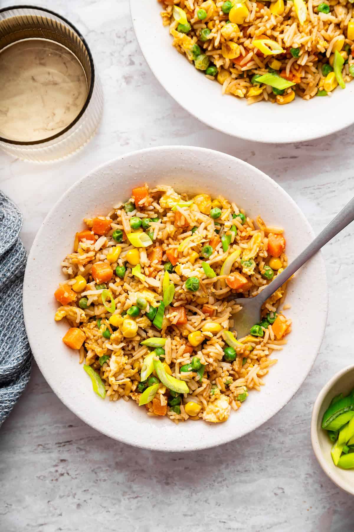 This 10-minute vegetable fried rice is the ultimate quick meal or side dish! Easy, flavorful, and perfect for busy weeknights. Fork in bowl of vegetable fried rice.