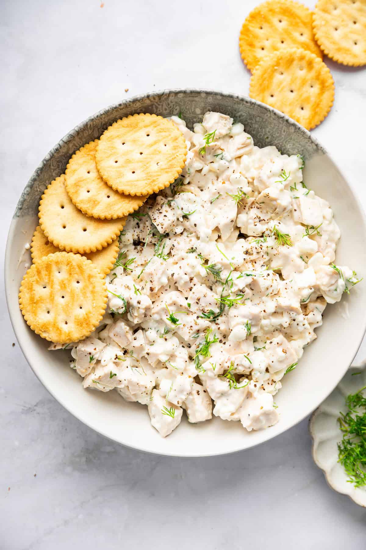 Bowl of cottage cheese chicken salad with crackers.