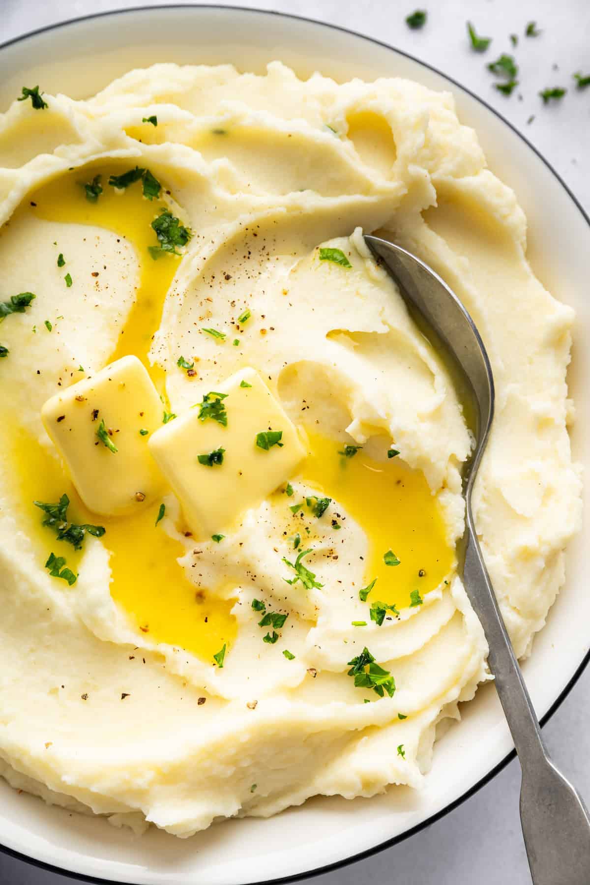 Spoon in bowl of Instant Pot mashed potatoes with butter.